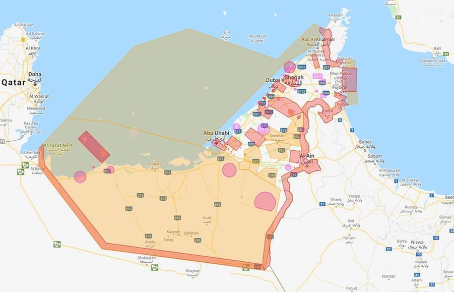 A fixed-wing mapping drone over a desert grading and infrastructure site in Dubai South with earthmoving equipment below