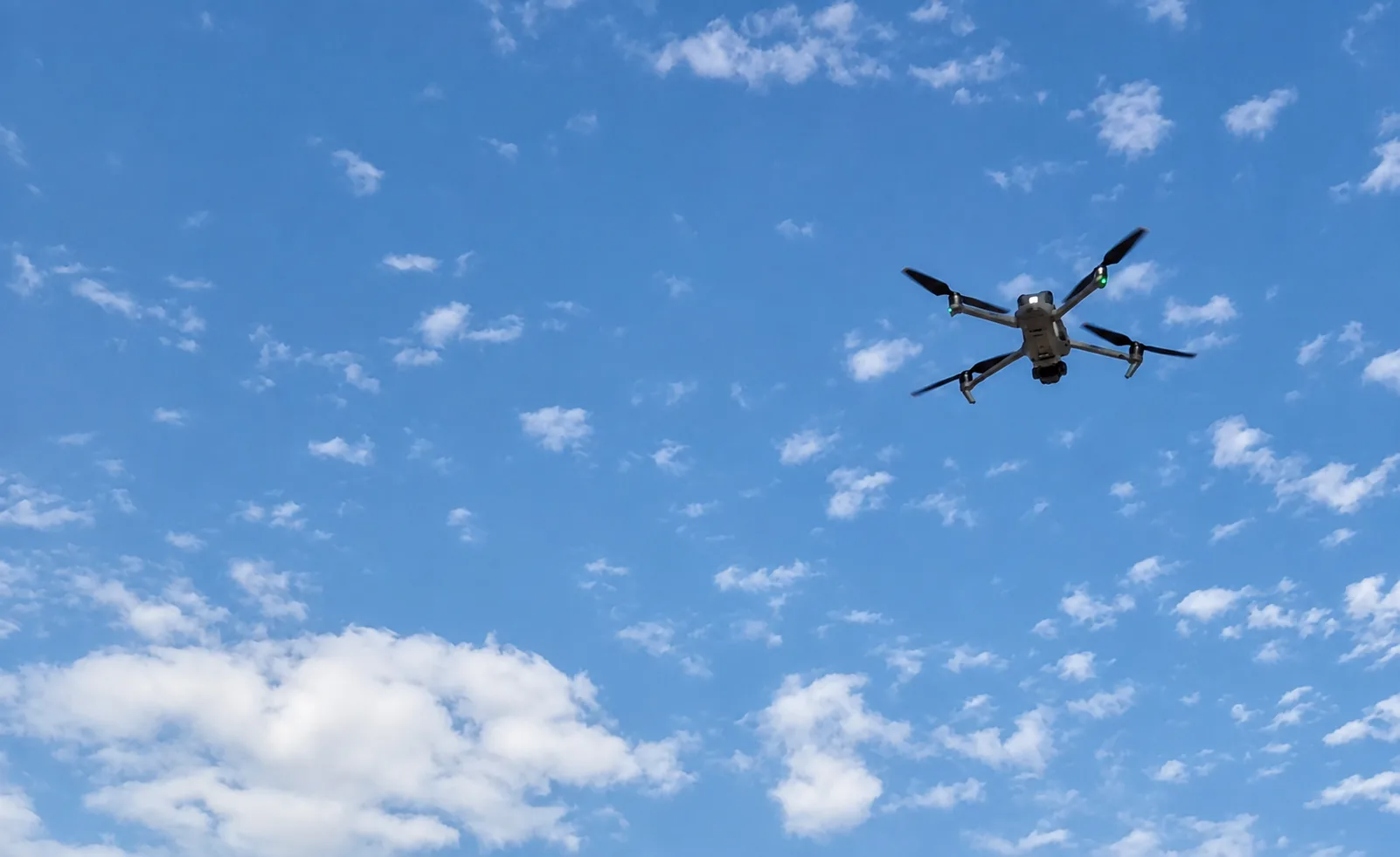 A camera drone flies against the sky during field operations at The Sustainable City on Yas Island, Abu Dhabi