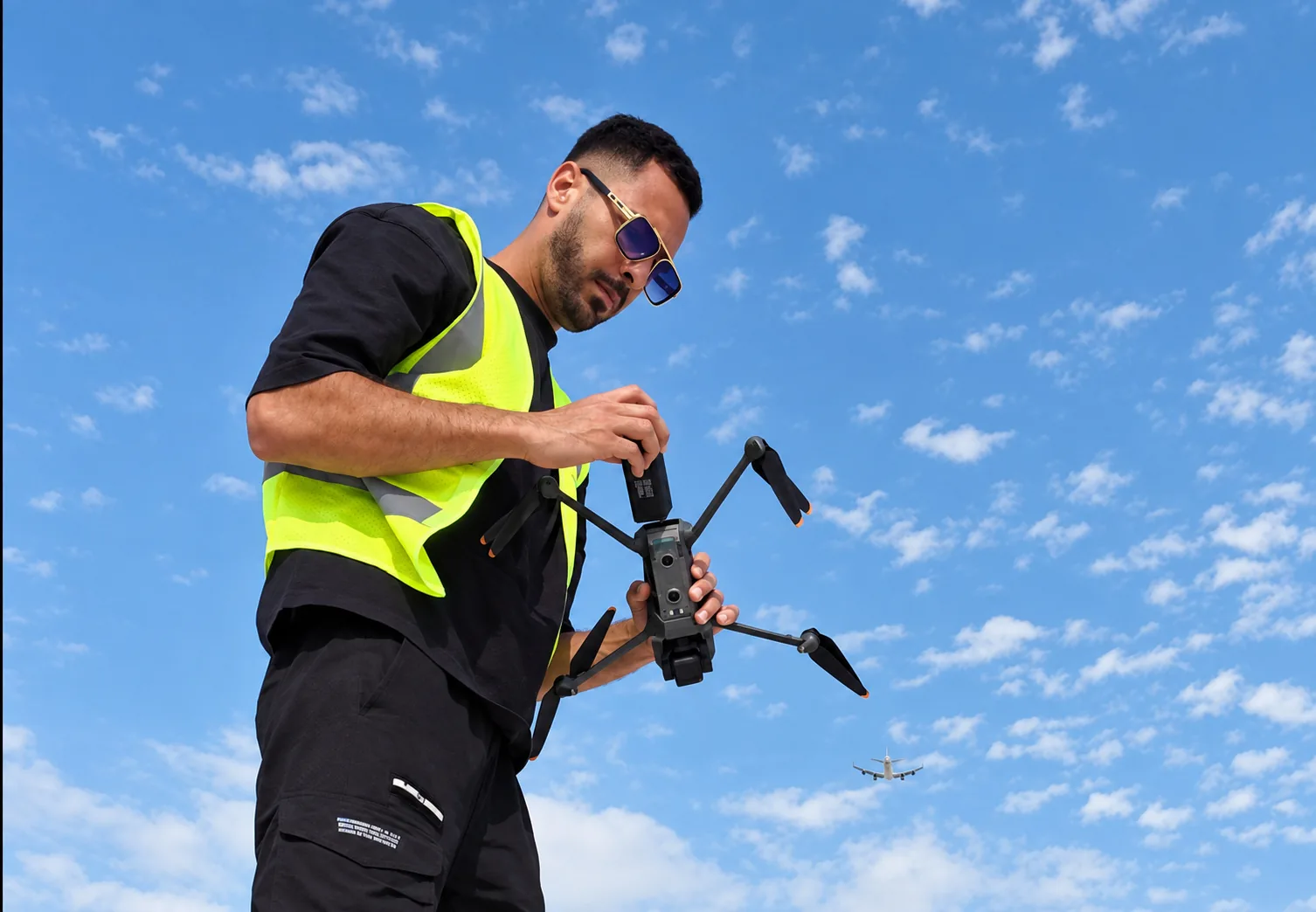 Pilot completing an equipment check before take-off on a rooftop in Abu Dhabi