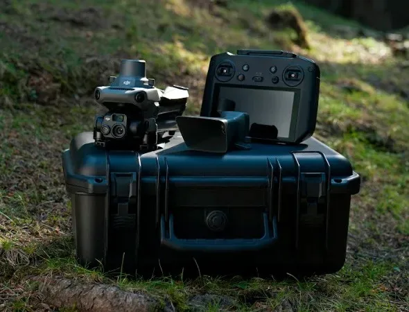 A drone and controller are arranged on a protective transport case outdoors