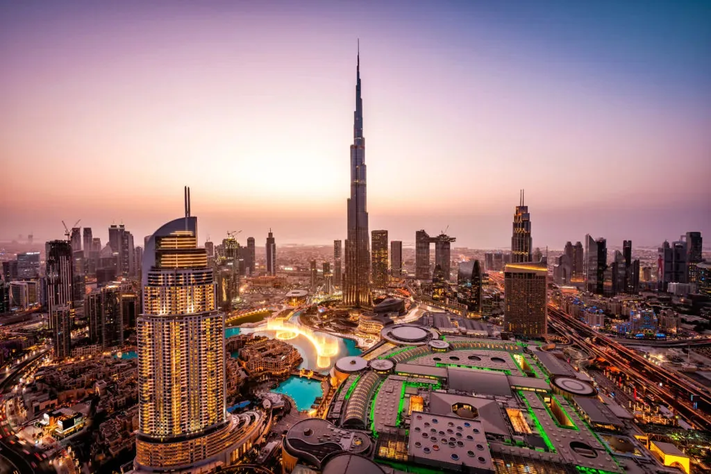 An elevated dusk view shows the Burj Khalifa and surrounding Downtown Dubai buildings and roads