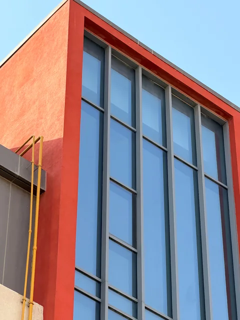 Red building façade and tall windows after cleaning