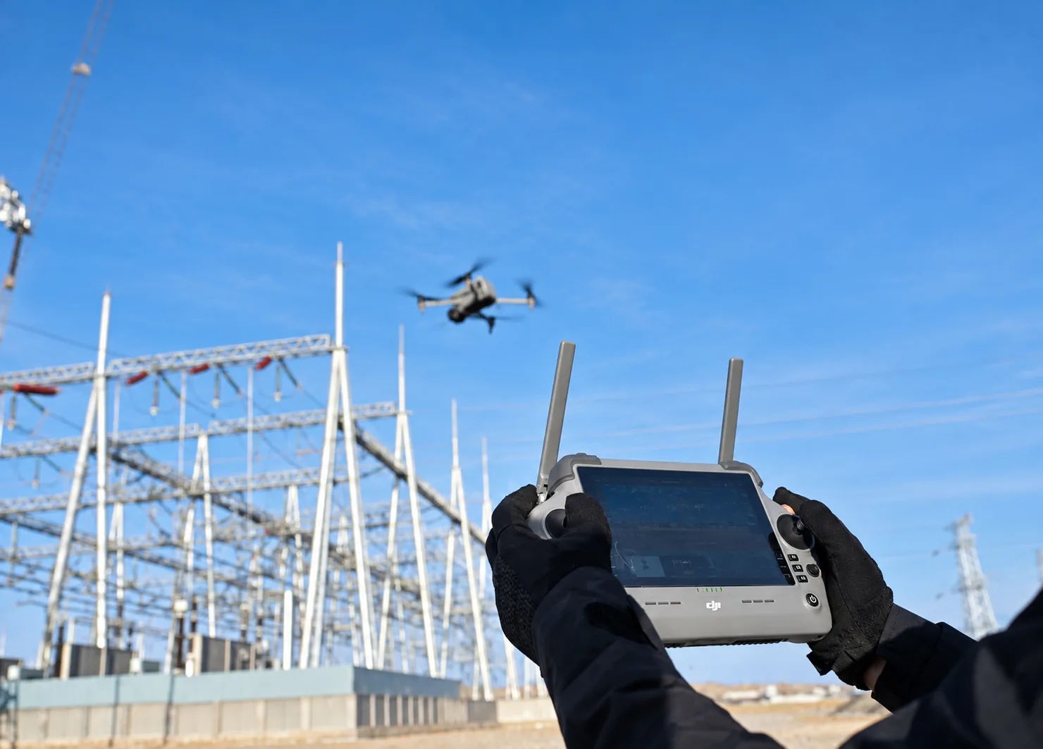 Drone operator capturing a building under construction from ground level