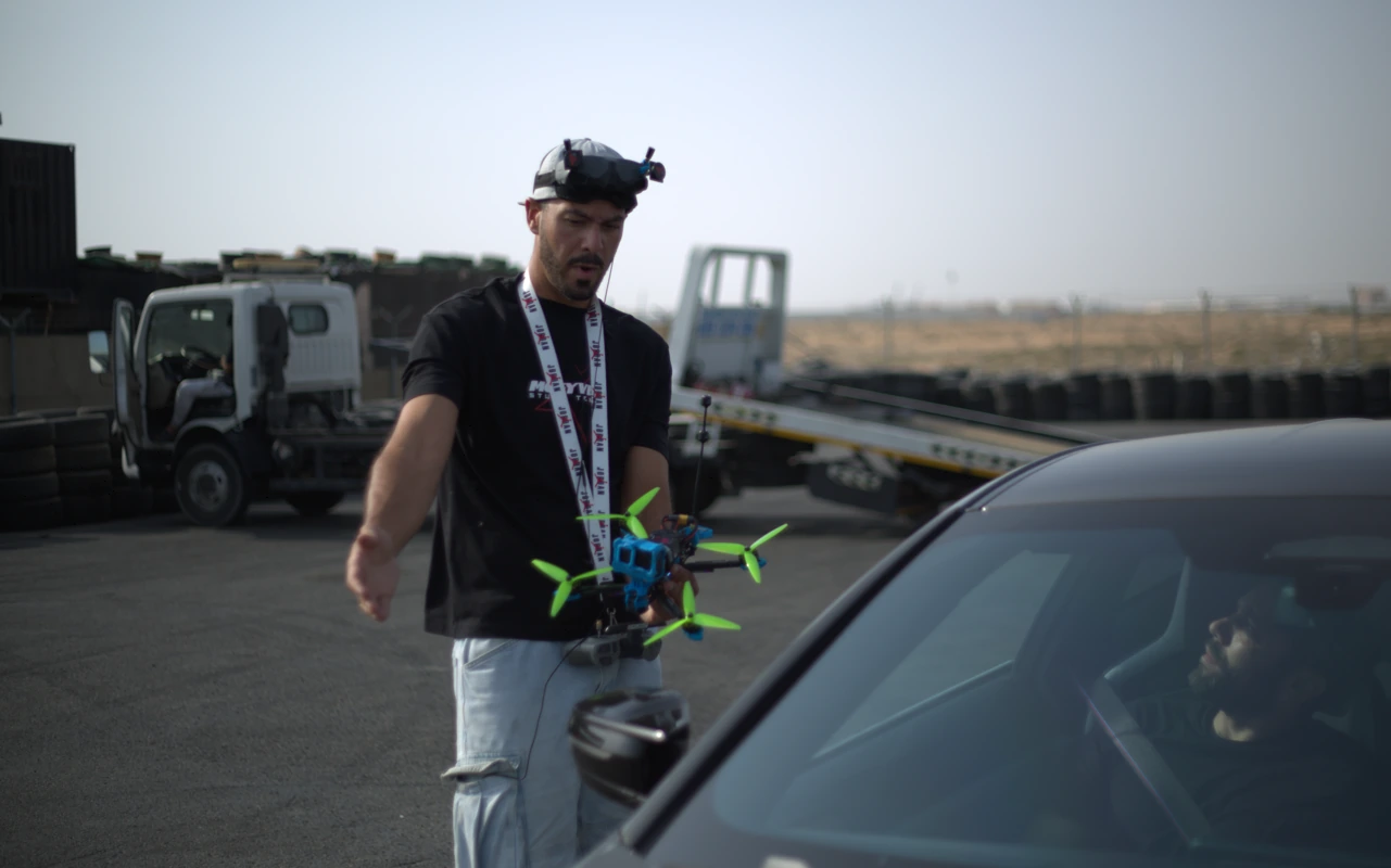 Filming crew running a pre-flight briefing beside a production vehicle