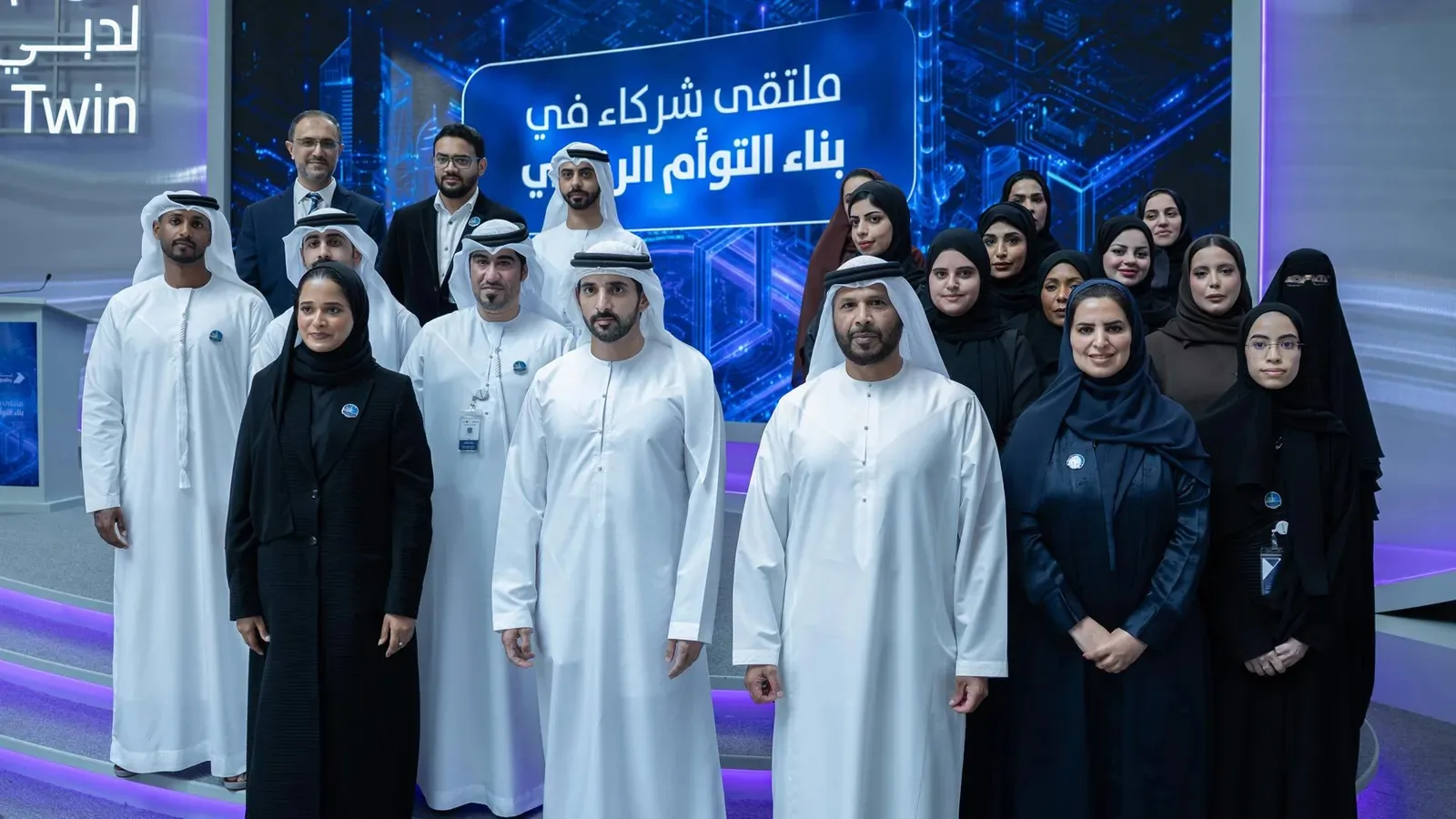 Attendees pose together in front of event signage referring to a digital twin initiative